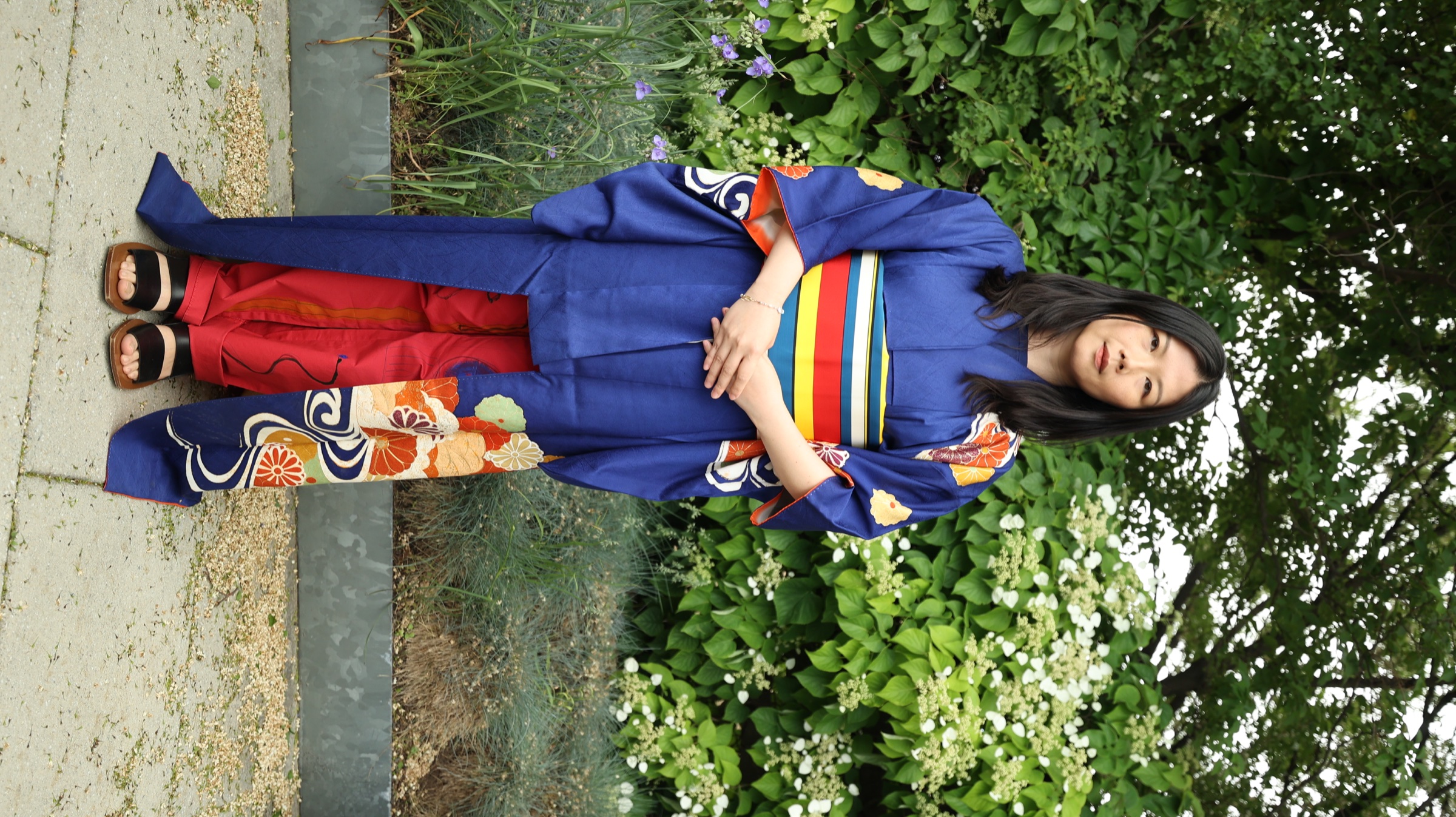 Woman wearing a blue floral kimono in a garden
