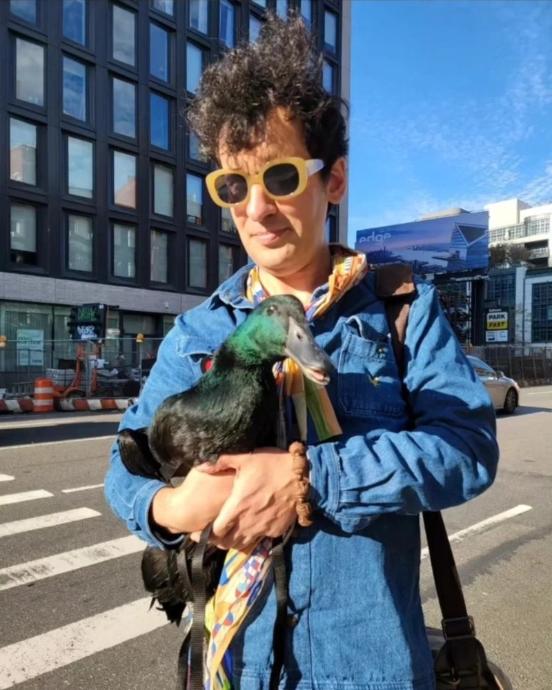 David De Hannay on a Manhattan street holding a duck