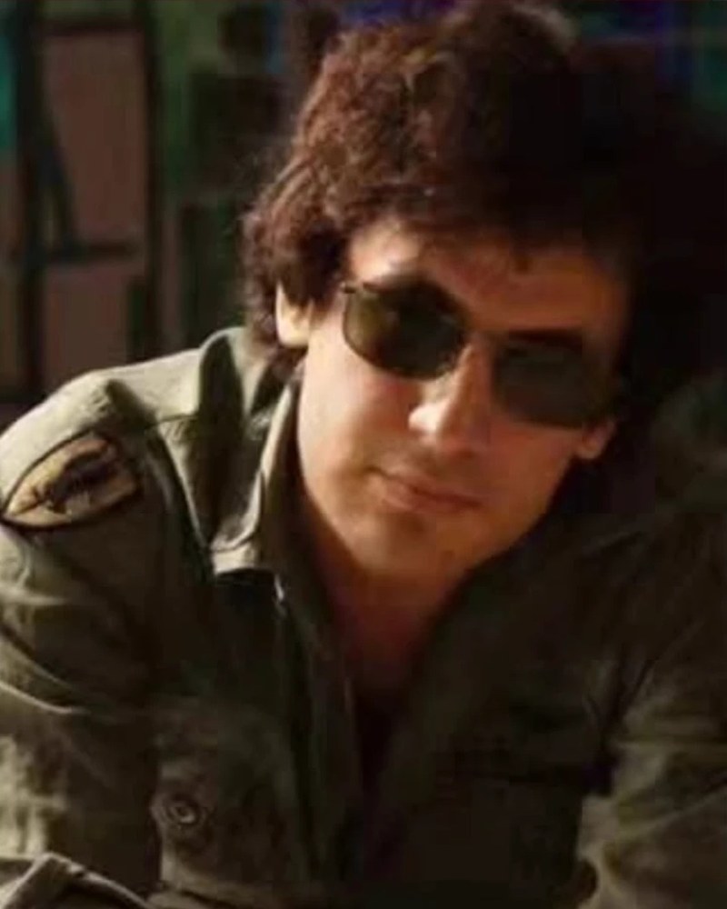 David De Hannay in sunglasses and a field jacket