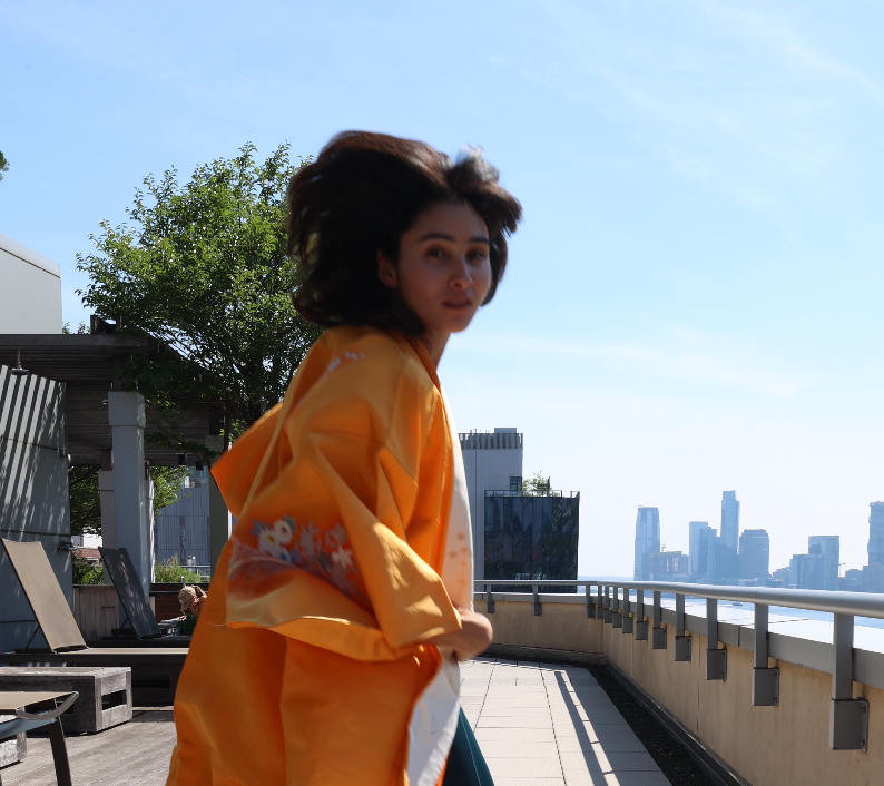 Dani wearing a golden kimono on a New York rooftop