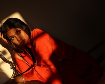 Woman in a red garment under a beam of light