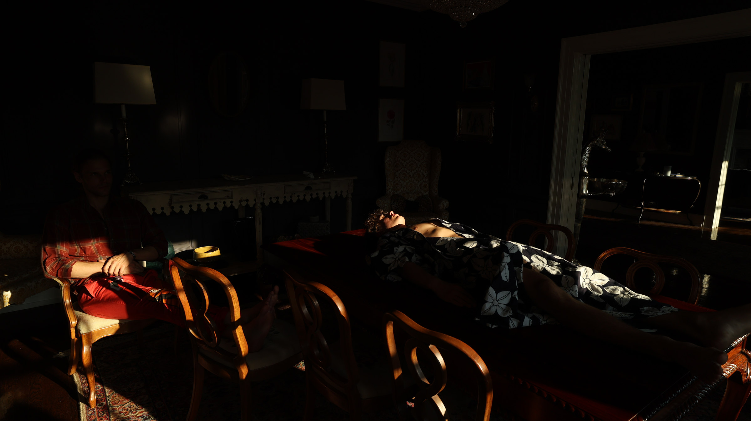 Two people in patterned garments in a dim interior