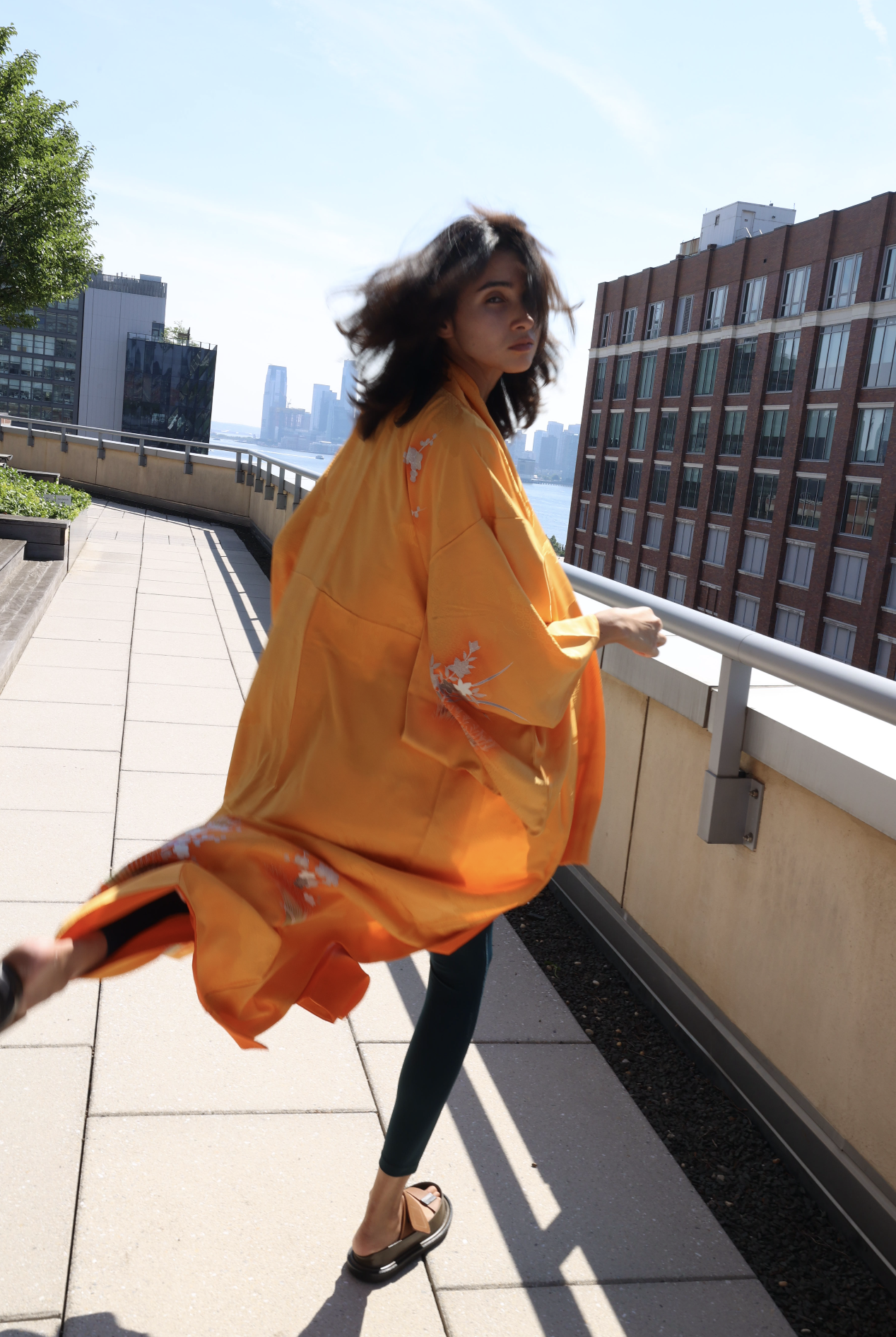 Orange kimono in motion on a rooftop