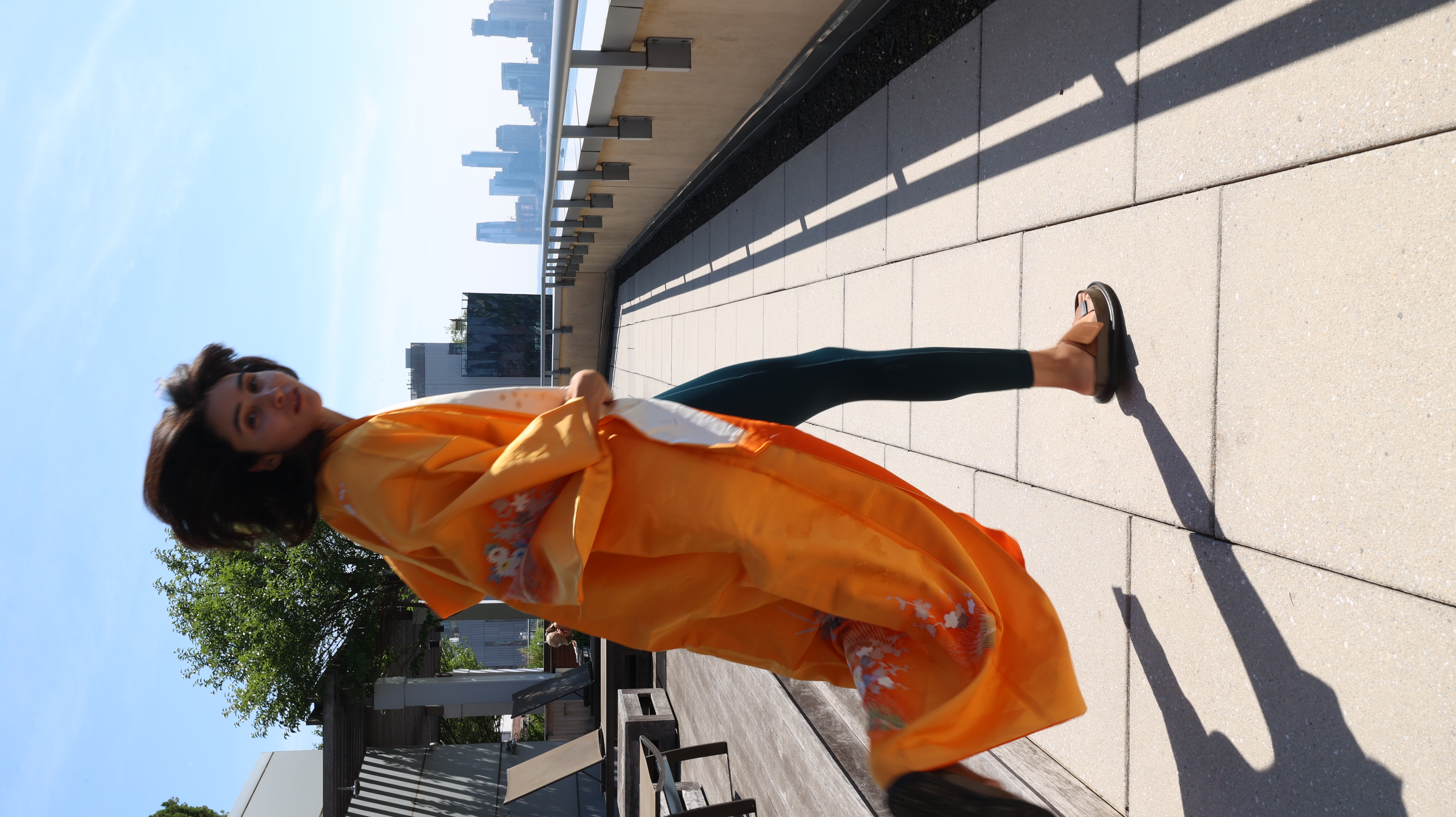 Woman in an orange kimono looking back on a New York rooftop